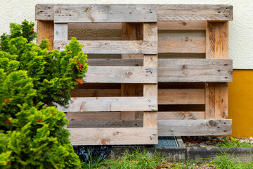 a euro pallet standing in front of a house wall