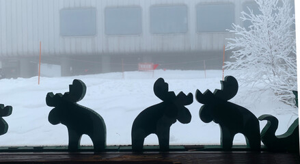 雪国の窓際に並ぶトナカイの人形