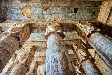 Colourful columns with the head of goddess Hathor and blue astronomical ceIling from the  Hypostyle Hall of the temple of Dendera, Egypt