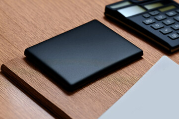 Blank business cards with calculator and pen on the wooden table.