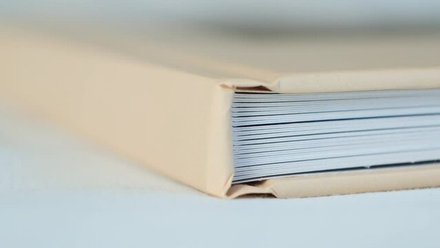 Large thick book photo album with beige cover close-up