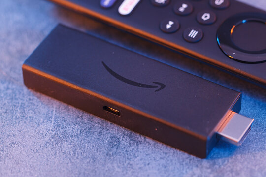 Milan, Italy - January 28, 2024: close up on Amazon Fire Stick Tv device and remote controller for tv streaming.