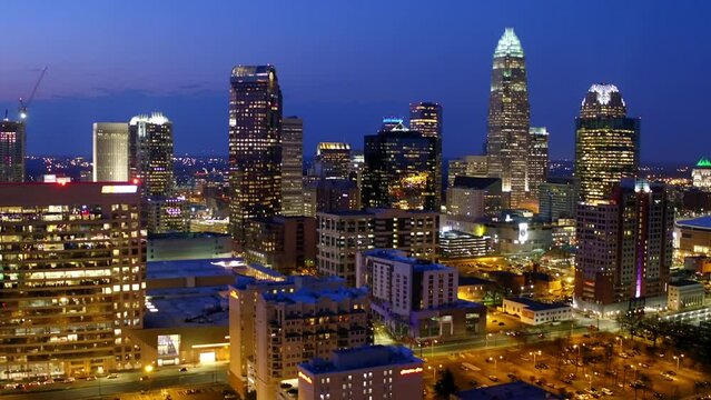 Aerial Shot Of Illuminated Modern Buildings In Residential City, Drone Flying Backwards At Night - Charlotte, North Carolina
