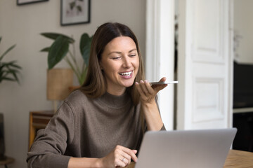 Cheerful entrepreneur woman using technology for remote job communication at home, talking on...
