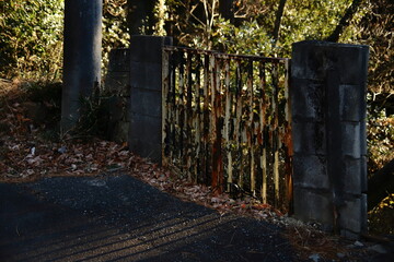 夕日に照らされる錆びた門