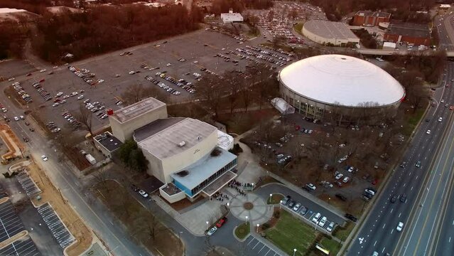 Aerial Tilt Down Shot Of Oven Auditorium And Bojangles Coliseum Arena In Residential City Under Clouds During Sunset - Charlotte, North Carolina