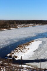 An ice-covered river in winter in the northern region. Winter landscape. Icing.