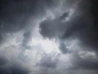 The sky was covered with black clouds, indicating heavy rain would fall.  A layer of thick dark clouds threatens heavy rain and increased humidity.