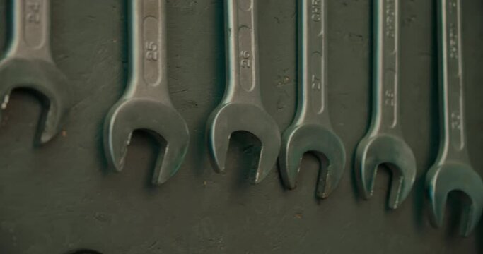 Close up on set of wrench tools on workshop wall. Different sizes of wrench metal work tools hanging on the wall