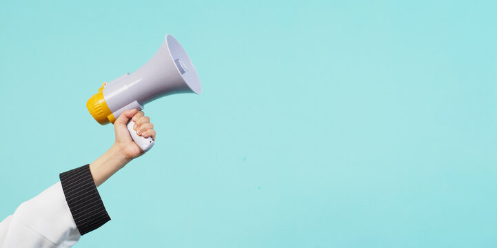 Hand hold megaphone and wear chef uniform on green mint or Tiffany Blue background.