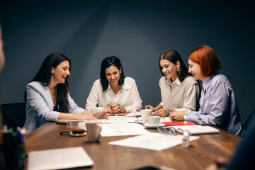 A happy businesswomen sitting at boardroom at having briefing about project.