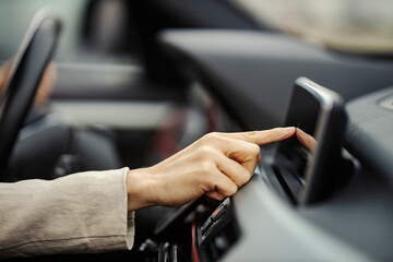 Close up of hand using gps in a car.