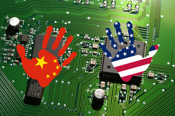Electronic board with processor and microchip with handprints with the colors of Chinese and USA Flags. Concept for global battle and monopoly on microchip manufacturing between China, Taiwan and USA