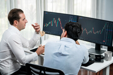 Investor stock office worker analyzing investment business trend on dynamic exchange rate database graph with monitor screen. Sharing information profit and loss in current situation crisis. Sellable.