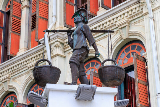Bronze statue of a fisherman carrying baskets on shoulder pole in Smith Street, Chinatown, Singapore