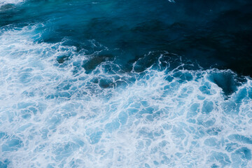 Aerial View of Ocean Waves Crashing into Rocky Coastline - obrazy, fototapety, plakaty