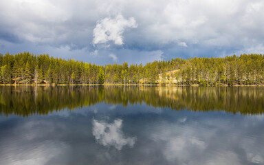 Dramatic cloudscape with a raising storm on a finnish lake surrounded by forest. Deep nature in Lapland, Finland.