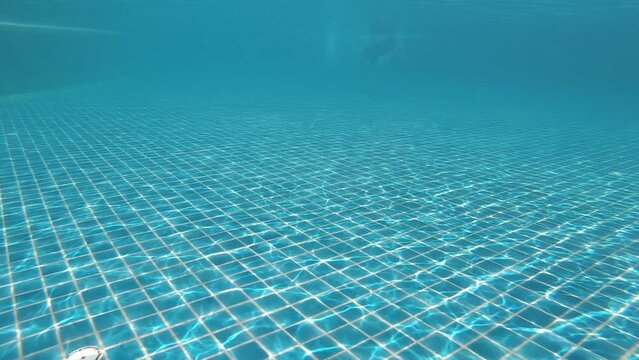 diving into the water on blue swimming pool, beautiful pool texture background, slow motion scene