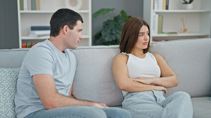 Beautiful couple sitting on sofa silent with problem at home