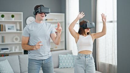 Beautiful couple playing dancing video game using virtual reality glasses at home