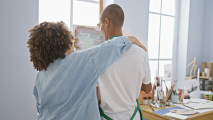 In an art studio, a man and woman artists exchange a heartwarming hug, drawing backwards together...