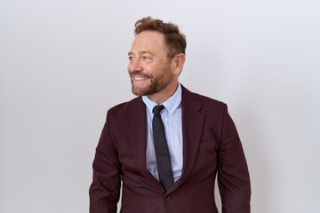 Middle age business man with beard wearing suit and tie looking away to side with smile on face, natural expression. laughing confident. - obrazy, fototapety, plakaty