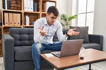 Young hispanic man psychologist having online session at psychology clinic