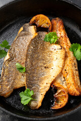 Pan fried sea bass fillets served with mashed potatoes and caramelised lemon