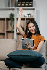 Excited woman work distant on computer talk on cellphone celebrate online win. Happy young female...