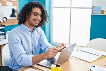 Young latin man business worker putting reminder paper on laptop at office