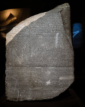 London, UK - December 10 2022 : Close up detail of the Rosetta Stone in the briths museum. This fragment of an ancient stela (an inscribed slab), most famous rock in world. 