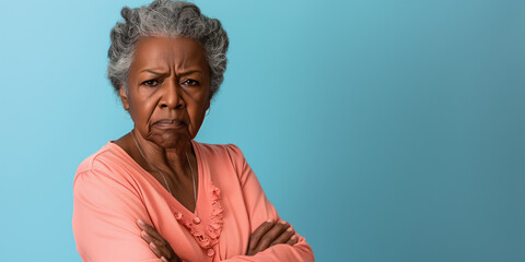Grumpy senior black woman looking at camera with resentment and disapproval, on solid background with copy space.