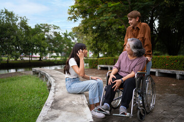 Asian careful caregiver or nurse taking care of the patient in a wheelchair.  Concept of a happy retirement with care from a caregiver and Savings and senior health insurance, a Happy Family