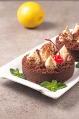 Delicious chocolate tart garnish with cherry and mint. Classic dessert.