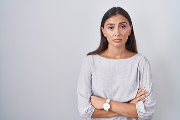 Young hispanic woman standing over white background looking sleepy and tired, exhausted for fatigue...