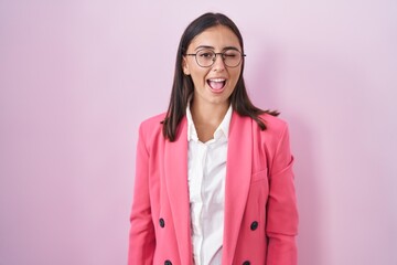 Young hispanic woman wearing business clothes and glasses winking looking at the camera with sexy expression, cheerful and happy face.