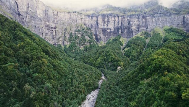 Giffre valley of mountain range with cascade and foggy in French Alps borderland at France