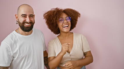 Joyous beautiful couple celebrating love together, standing confident over isolated pink...