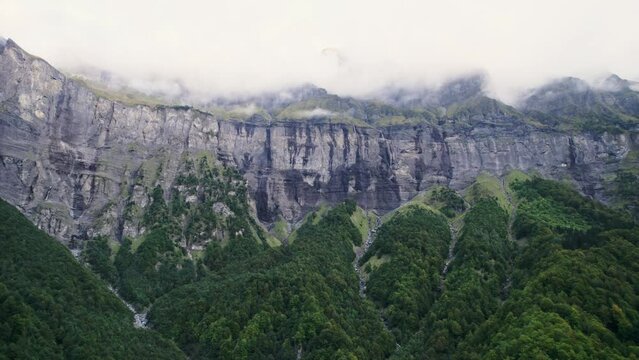 Giffre valley of mountain range with cascade and foggy in French Alps borderland at France