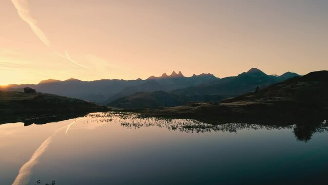 Sunrise shines over Lac Guichard with Arves massif and lake reflection in autumn at Aiguilles d'Arves, French Alps, France