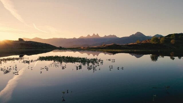 Sunrise shines over Lac Guichard with Arves massif and lake reflection in autumn at Aiguilles d'Arves, French Alps, France