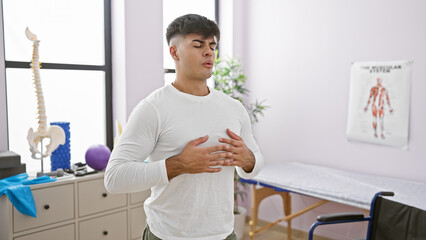 At his balance point, a portrait of a young, handsome hispanic man finding calm by meditating and...