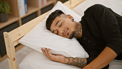 Young latin man lying on bed sleeping at bedroom - obrazy, fototapety, plakaty