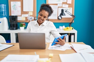 African american woman business worker using laptop and touchpad at office