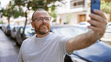 Confident caucasian man, all smiles while making a fun-filled selfie with his smartphone on a...