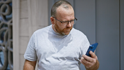 Caucasian man using smartphone with serious expression at street