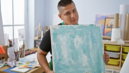 Passionate young latin man artist drawing at his art studio, immersed in his hobby and creativity