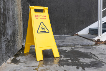 wet floor sign with water drops on wet stone floor.