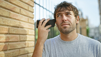 Young man listening to voice message at the street