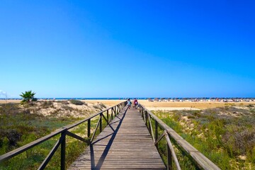 Conil de la Frontera: wooden boardwalk from the city towards the beach, Playa de los Bateles, Costa de la Luz, Andalusia, Spain